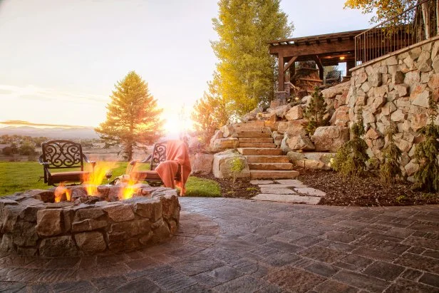 Red Brick Circular Fire Pit with Rustic Stone Accents and Lanterns